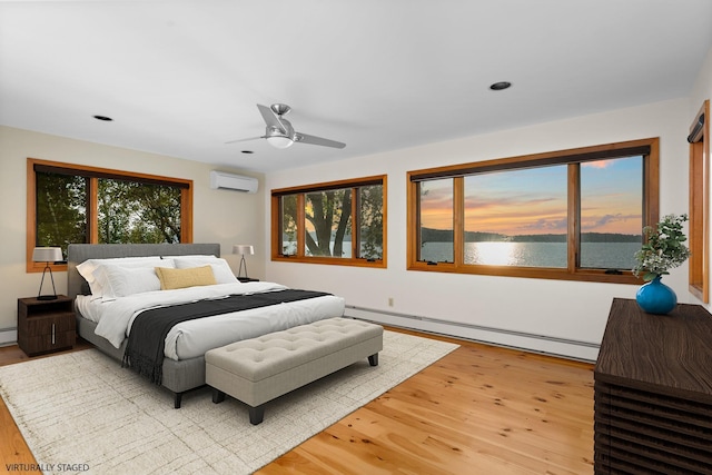 430 Clearwater Rd, Shelburne, VT 05482 - bedroom with an AC wall unit, a baseboard radiator, light wood-type flooring, a water view, and recessed lighting