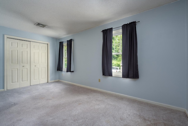 1 Village Falls Way Unit 1, Merrimack, NH 03054 - unfurnished bedroom featuring carpet flooring, a closet, baseboards, and a textured ceiling