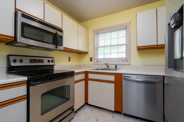 1 Village Falls Way Unit 1, Merrimack, NH 03054 - kitchen featuring appliances with stainless steel finishes, a sink, light countertops, white cabinets, and light flooring