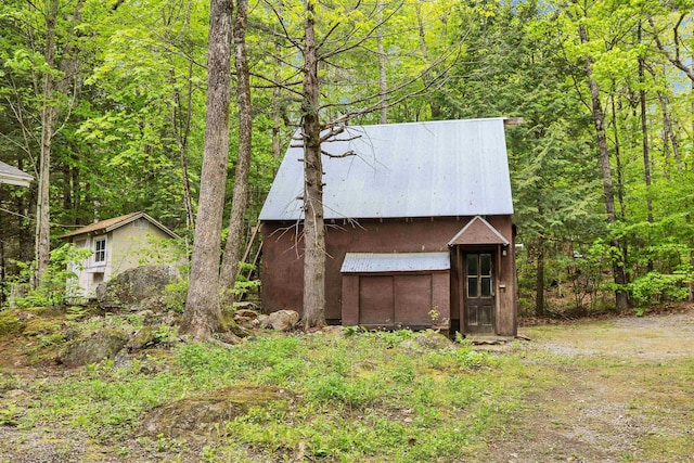 29 Centennial Dr, Webster, NH 03303 - view of front facade with an outbuilding, metal roof, and a view of trees