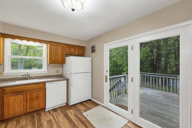 406 Lower Ridge Rd, Loudon, NH 03307 - kitchen with white appliances, a sink, light wood-style floors, brown cabinetry, and baseboards