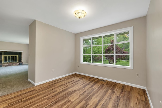 406 Lower Ridge Rd, Loudon, NH 03307 - spare room with baseboards, wood finished floors, and a brick fireplace