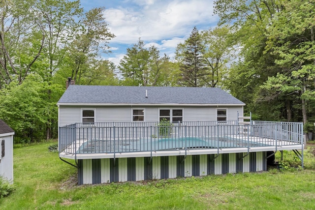 406 Lower Ridge Rd, Loudon, NH 03307 - back of property with a deck, a chimney, a lawn, roof with shingles, and view of scattered trees
