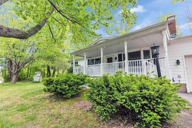 29 Laurel St, Goffstown, NH 03045 - view of home's exterior featuring covered porch, a chimney, and a lawn