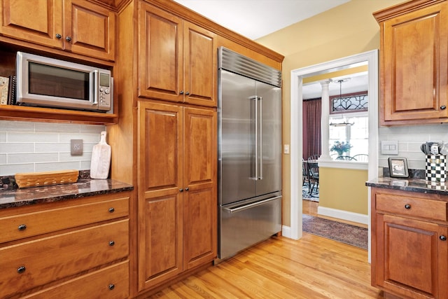 5 Smithfield Ln, Bedford, NH 03110 - kitchen featuring stainless steel appliances, brown cabinets, dark stone countertops, and decorative backsplash