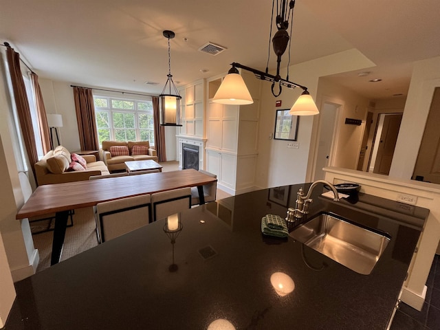 102 Forest Drive 310Interval I W/Lockout 308, Warren, VT 05674 - kitchen with a sink, open floor plan, a fireplace, decorative light fixtures, and dark countertops