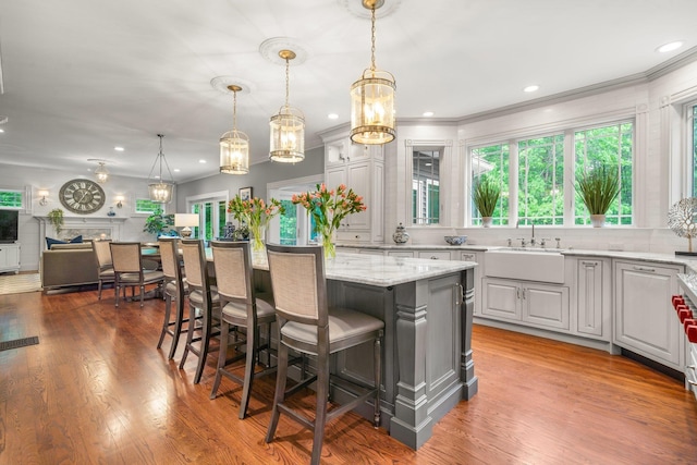 52 Hardy Rd, Bedford, NH 03110 - kitchen with a sink, a chandelier, a breakfast bar area, a center island, and light stone countertops