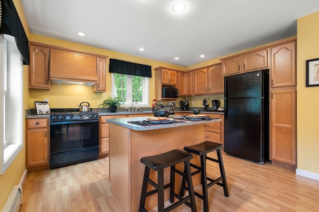 52 Hardy Rd, Bedford, NH 03110 - kitchen featuring black appliances, baseboard heating, light wood-style floors, a center island, and a kitchen bar