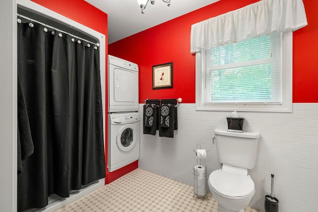 52 Hardy Rd, Bedford, NH 03110 - bathroom featuring stacked washer / drying machine, wainscoting, toilet, curtained shower, and tile walls