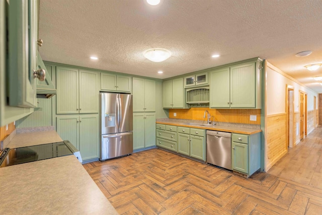 122 Flagg Rd, Rochester, NH 03839 - kitchen featuring stainless steel appliances, green cabinets, a sink, a textured ceiling, and light countertops