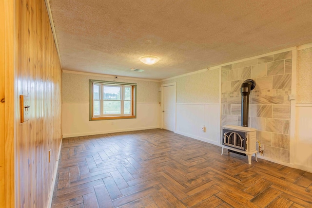 122 Flagg Rd, Rochester, NH 03839 - unfurnished room with a textured ceiling, a wood stove, wainscoting, and ornamental molding