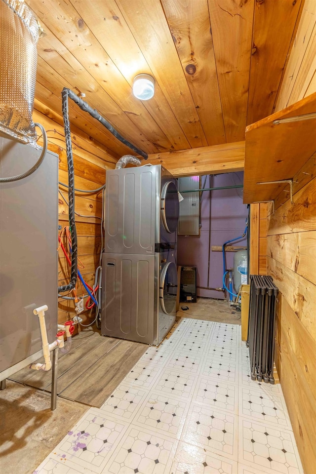 122 Flagg Rd, Rochester, NH 03839 - laundry room with stacked washer and clothes dryer, wooden ceiling, tile patterned floors, and wood walls