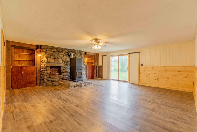 122 Flagg Rd, Rochester, NH 03839 - unfurnished living room featuring a textured ceiling, wood finished floors, a ceiling fan, wood walls, and built in features
