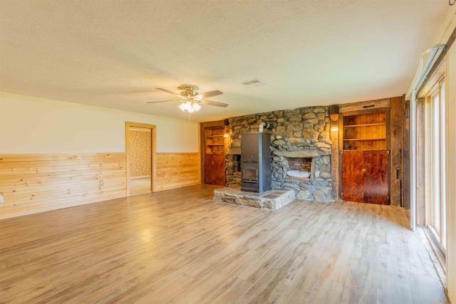 122 Flagg Rd, Rochester, NH 03839 - unfurnished living room with a textured ceiling, wood finished floors, a ceiling fan, wooden walls, and a wainscoted wall