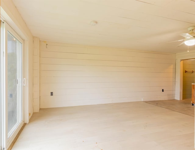122 Flagg Rd, Rochester, NH 03839 - spare room with light wood-style flooring, healthy amount of natural light, wood walls, and a ceiling fan