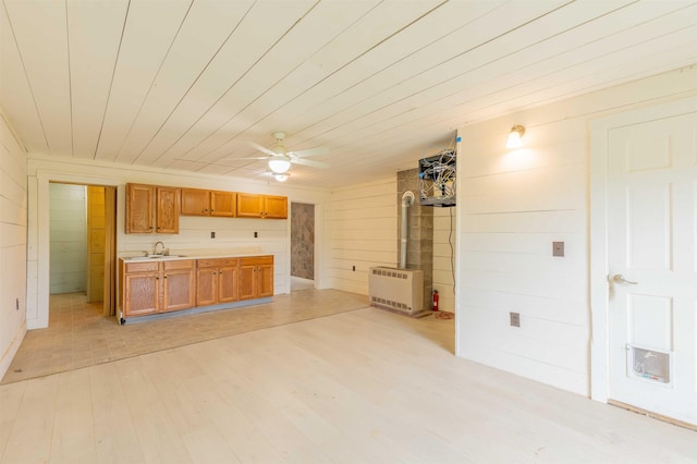 122 Flagg Rd, Rochester, NH 03839 - kitchen featuring a sink, wooden walls, light wood finished floors, ceiling fan, and light countertops
