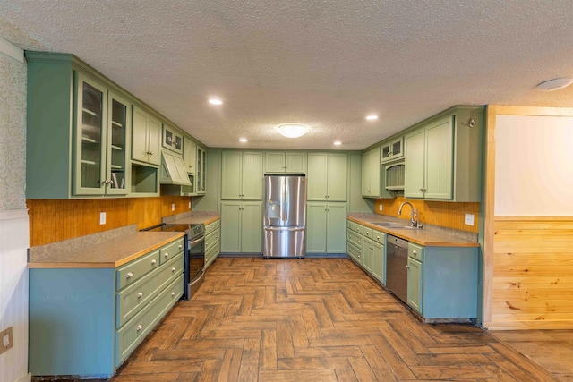 122 Flagg Rd, Rochester, NH 03839 - kitchen featuring appliances with stainless steel finishes, green cabinets, a sink, a textured ceiling, and premium range hood