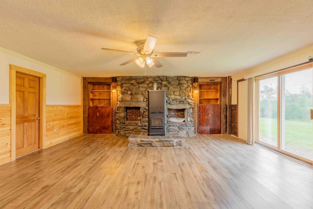 122 Flagg Rd, Rochester, NH 03839 - unfurnished living room with a textured ceiling, wood finished floors, wood walls, built in features, and a ceiling fan