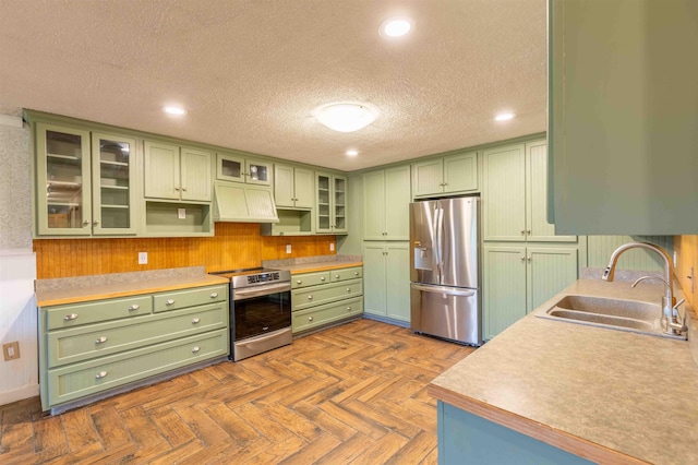 122 Flagg Rd, Rochester, NH 03839 - kitchen featuring green cabinets, appliances with stainless steel finishes, a sink, custom exhaust hood, and a textured ceiling