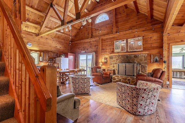 31 Highland View Rd, Weston, VT 05161 - living room featuring wooden ceiling with exposed beams, wood walls, high vaulted ceiling, wood finished floors, and a stone fireplace