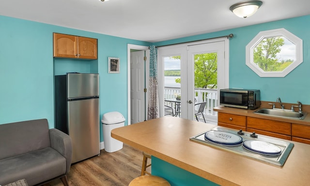 1144 Weirs Blvd Unit 20, Laconia, NH 03246 - kitchen with appliances with stainless steel finishes, a sink, wood finished floors, brown cabinets, and light countertops