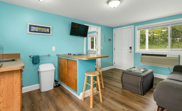1144 Weirs Blvd Unit 20, Laconia, NH 03246 - kitchen with wood finished floors, baseboards, a kitchen bar, and a peninsula