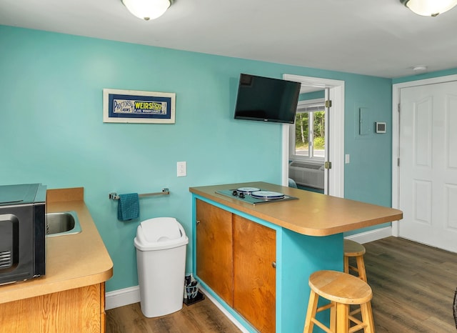 1144 Weirs Blvd Unit 20, Laconia, NH 03246 - kitchen featuring dark wood-style flooring, black microwave, a kitchen breakfast bar, a peninsula, and baseboards