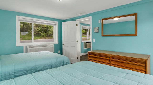 1144 Weirs Blvd Unit 20, Laconia, NH 03246 - bedroom featuring an AC wall unit, baseboards, and wood finished floors