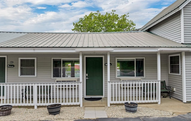1144 Weirs Blvd Unit 20, Laconia, NH 03246 - view of exterior entry featuring a porch and metal roof