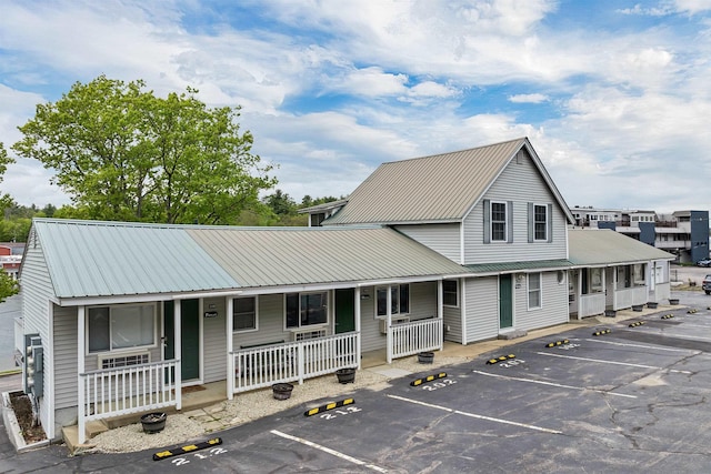 1144 Weirs Blvd Unit 20, Laconia, NH 03246 - view of front of property featuring covered porch, uncovered parking, and metal roof