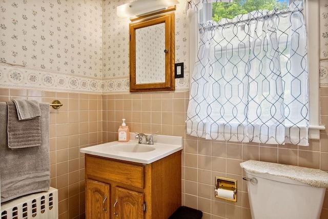 47 Dell Rd, Springfield, VT 05156 - bathroom with radiator, tile walls, vanity, wallpapered walls, and toilet