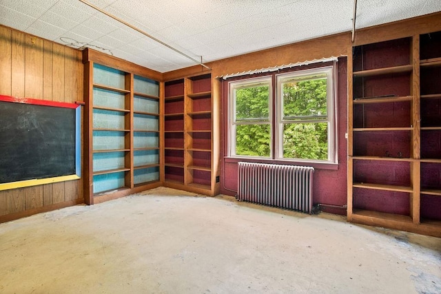 47 Dell Rd, Springfield, VT 05156 - unfurnished room featuring radiator, concrete floors, and wood walls
