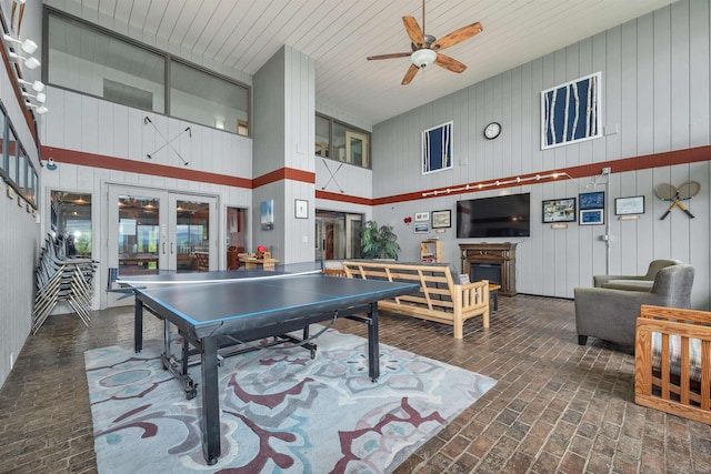 375 Endicott N St Unit 103, Laconia, NH 03246 - recreation room with a high ceiling, brick floors, french doors, a ceiling fan, and wooden walls