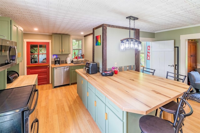 95 Main St, Wells River, VT 05081 - kitchen with stainless steel appliances, wooden counters, green cabinetry, light wood-type flooring, and an ornate ceiling