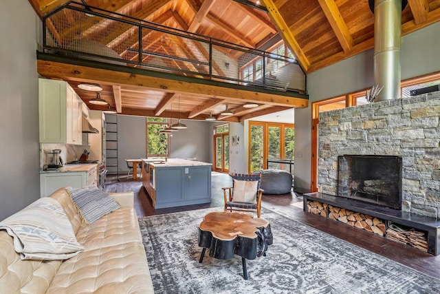 249 Falls Brook Ln, Stowe, VT 05672 - living area with wood ceiling with exposed beams, wood finished floors, a stone fireplace, and high vaulted ceiling