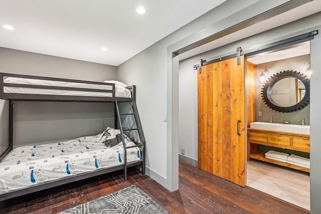 249 Falls Brook Ln, Stowe, VT 05672 - bedroom with wood finished floors, recessed lighting, baseboards, connected bathroom, and a barn door