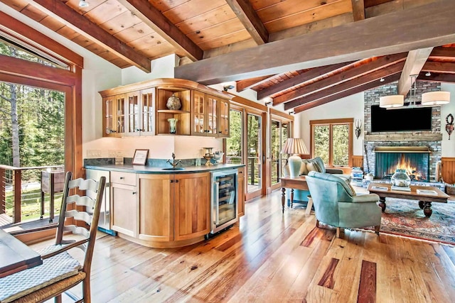 87 Deerpath Rd, New London, NH 03257 - kitchen featuring beverage cooler, open floor plan, light wood-style flooring, a sink, and wood ceiling