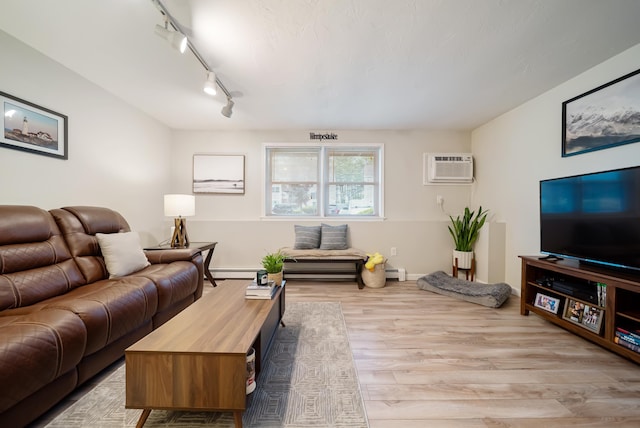 205 Circle Rd Unit 2, Manchester, NH 03103 - living area with a wall unit AC, wood finished floors, rail lighting, baseboards, and baseboard heating