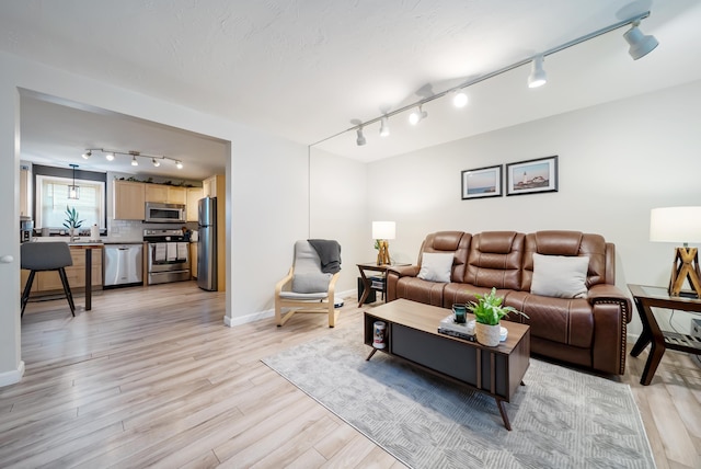 205 Circle Rd Unit 2, Manchester, NH 03103 - living area with track lighting, light wood-type flooring, and baseboards