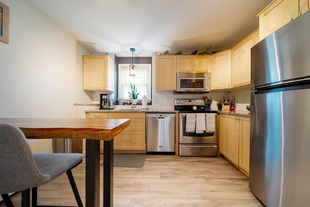 205 Circle Rd Unit 2, Manchester, NH 03103 - kitchen featuring stainless steel appliances, light brown cabinetry, light wood-style floors, and decorative backsplash