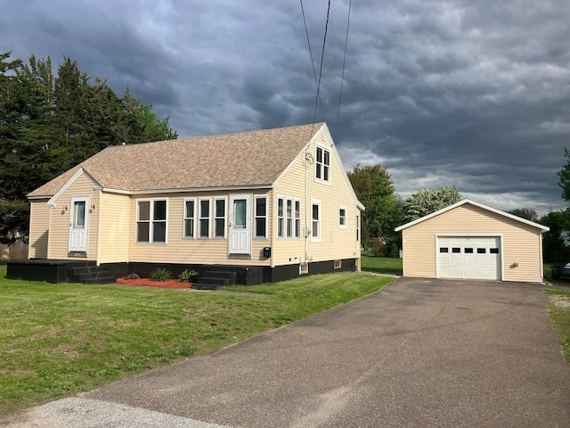 98 Canada St, Swanton, VT 05488 - view of front of house with an outdoor structure, roof with shingles, a garage, asphalt driveway, and a front yard