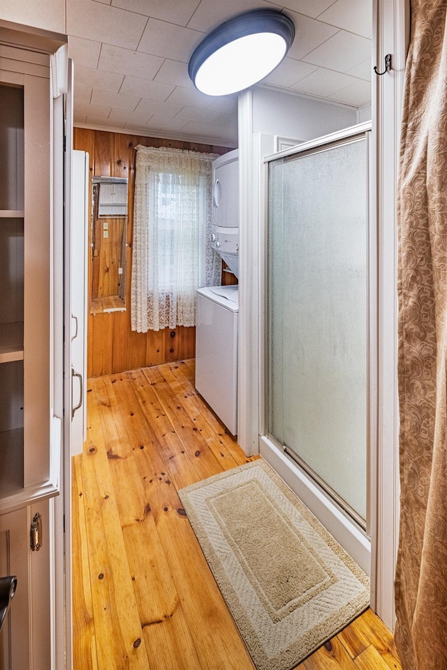 22 Kingsbury Dr, Milton, NH 03851 - bathroom with estacked washer and dryer, hardwood / wood-style floors, wood walls, and a shower stall