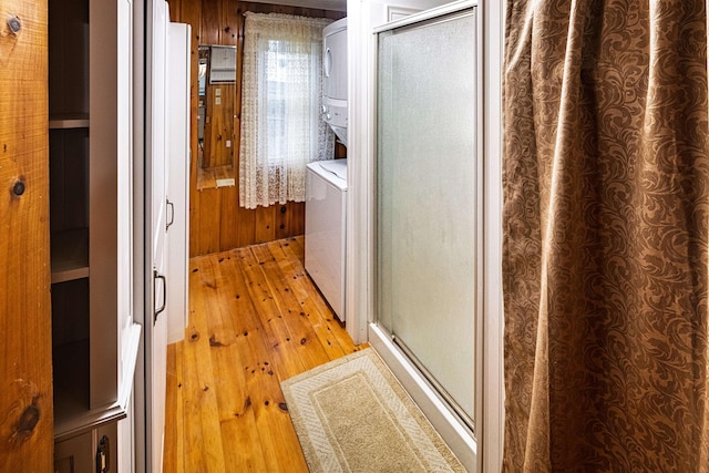 22 Kingsbury Dr, Milton, NH 03851 - full bathroom with estacked washer and dryer, wood-type flooring, a stall shower, and wood walls