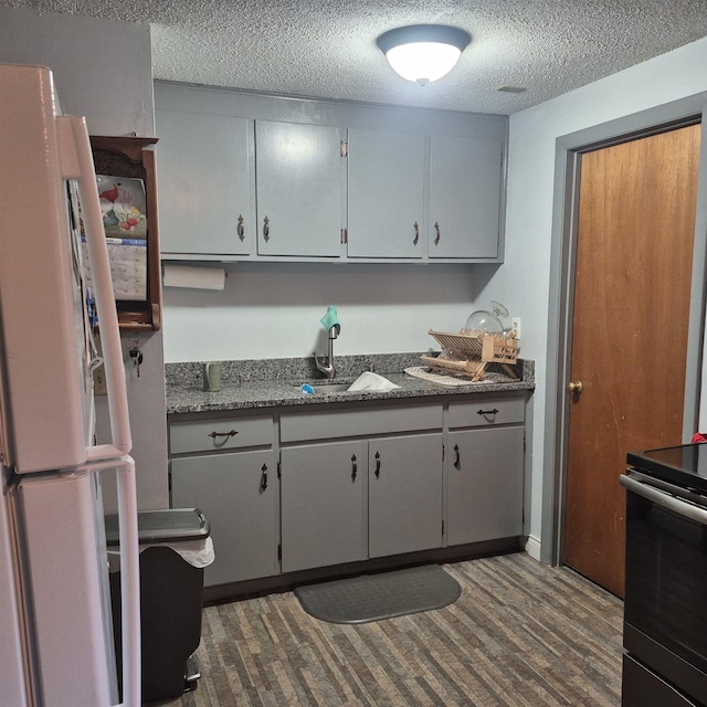 16 Oakwood Dr Unit 16, Claremont, NH 03743 - kitchen featuring freestanding refrigerator, a sink, electric stove, a textured ceiling, and dark wood-style flooring
