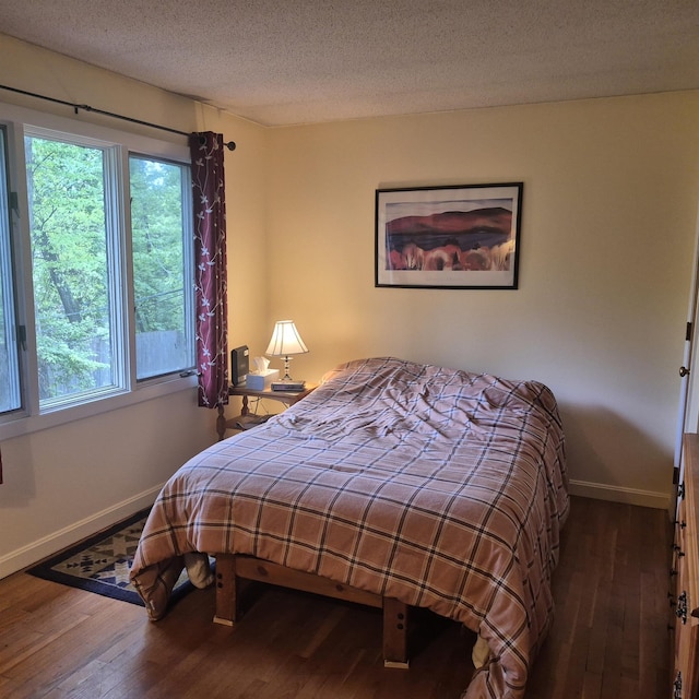 16 Oakwood Dr Unit 16, Claremont, NH 03743 - bedroom with baseboards, wood-type flooring, multiple windows, and a textured ceiling