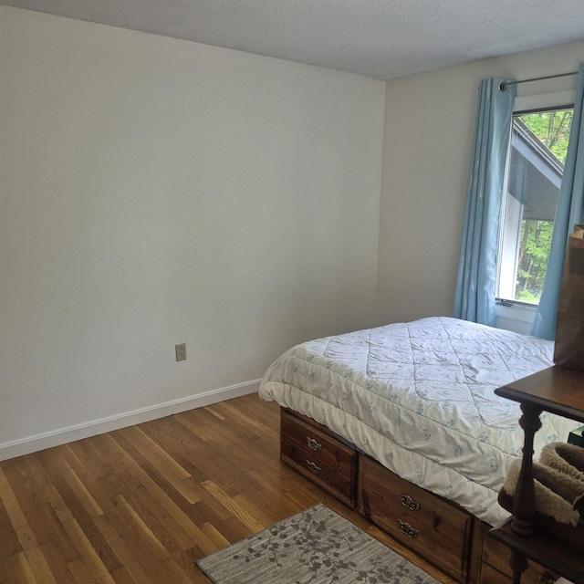 16 Oakwood Dr Unit 16, Claremont, NH 03743 - bedroom with dark wood-style floors, baseboards, and a textured ceiling