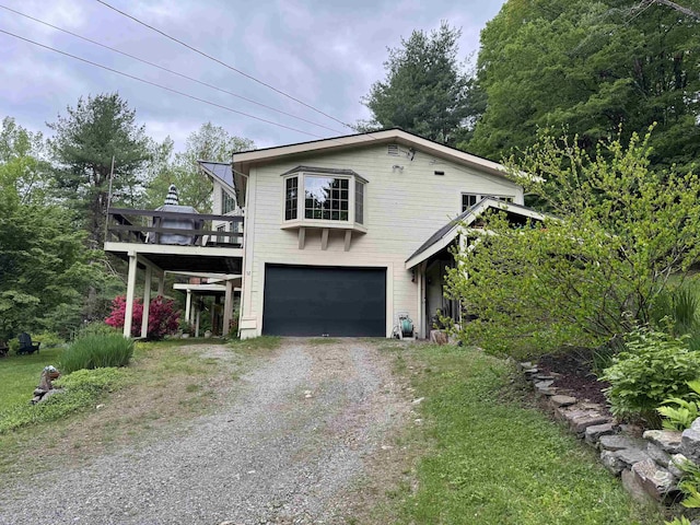 32 Christie Ln, Brattleboro, VT 05301 - view of front of house featuring dirt driveway, a garage, and a wooden deck