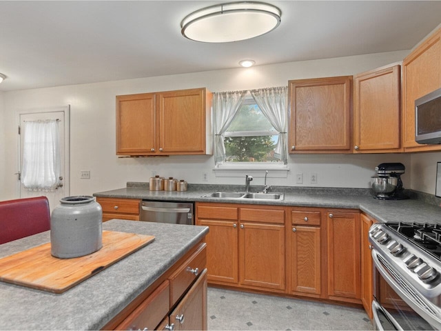 8 Checkerberry Sq Unit 106, Milton, VT 05468 - kitchen featuring a sink, appliances with stainless steel finishes, dark countertops, and brown cabinetry