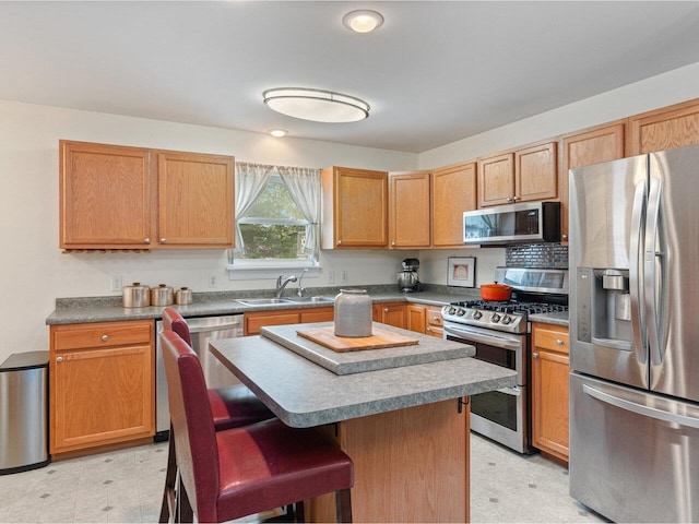 8 Checkerberry Sq Unit 106, Milton, VT 05468 - kitchen with appliances with stainless steel finishes, a sink, light floors, a kitchen bar, and a center island