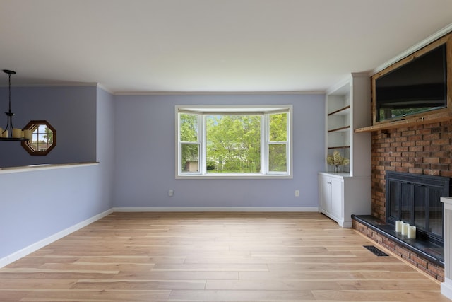 82 Stirrup Cir, Williston, VT 05495 - unfurnished living room featuring ornamental molding, light wood-style floors, a fireplace, and baseboards